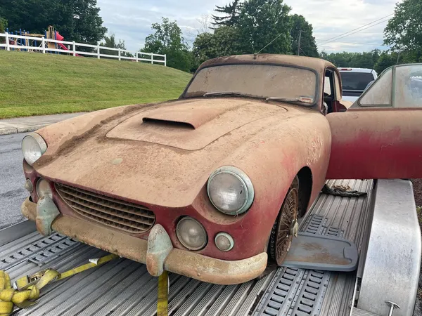 Dusty dirty AC Greyhound being pulled off of a trailer at our shop